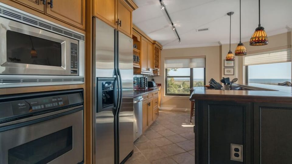 This well-appointed kitchen blends function with style, featuring stainless steel appliances, custom cabinetry, and generous counter space for easy meal prep.