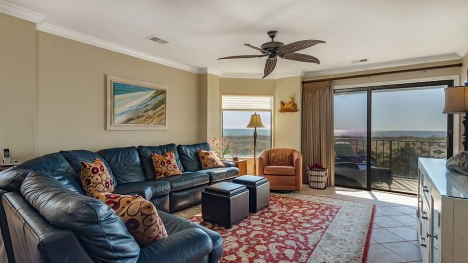 This inviting living area is designed for comfort and connection, with ample seating, warm coastal tones, and thoughtful furnishings throughout.