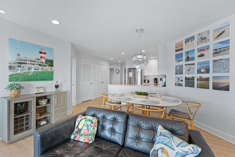 This bright and inviting living room offers a relaxing coastal feel with soft neutral furnishings, abundant natural light, and easy indoor–outdoor flow.