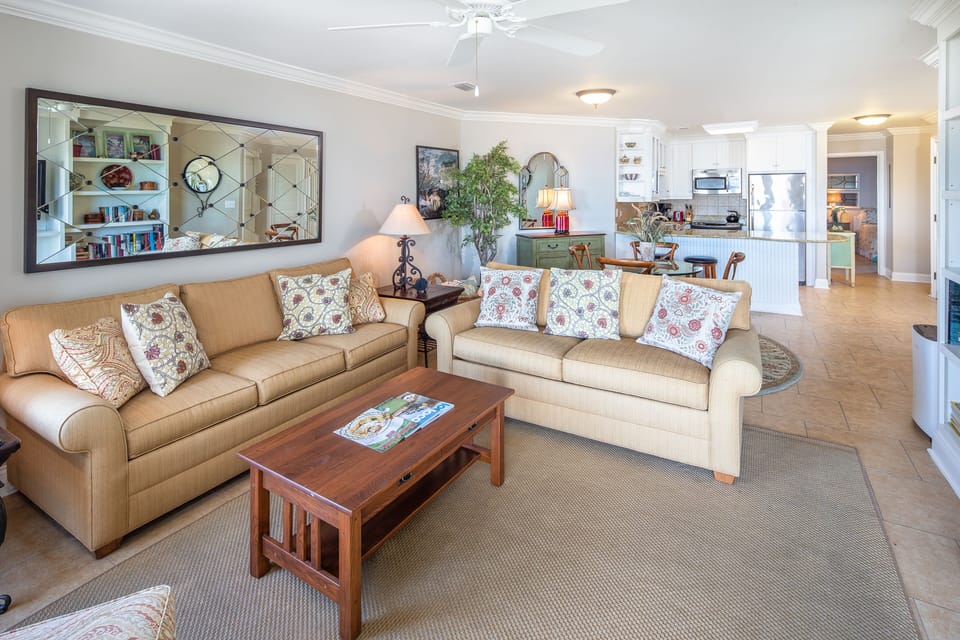This inviting living area is designed for comfort and connection, with ample seating, warm coastal tones, and thoughtful furnishings throughout.