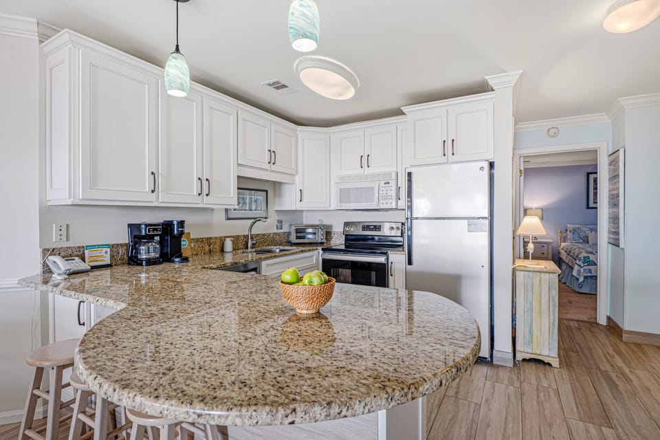 This well-appointed kitchen features crisp white cabinetry, stainless steel appliances, and a spacious peninsula.