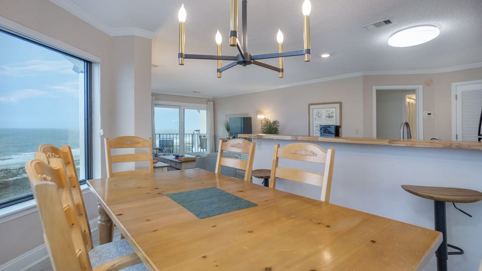 This bright dining area seamlessly connects to the living room, creating an open and inviting space for gathering after a day at the beach.