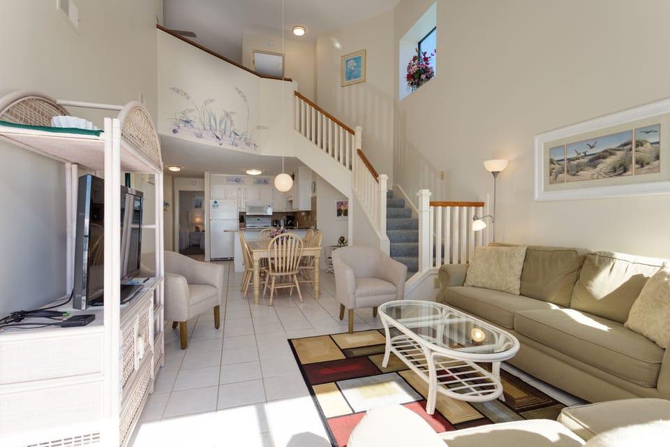 Area is arranged for easy conversation and movie nights, while the open staircase adds architectural interest without interrupting the sightlines.