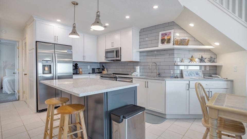 Enjoy the updated kitchen featuring a sleek countertop bar that offers additional seating—perfect for casual meals or gathering with family.