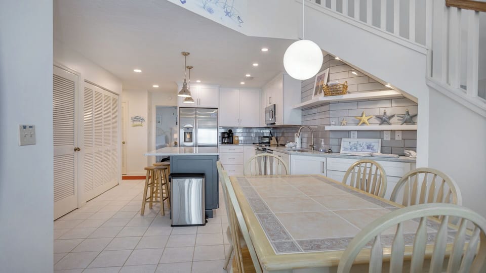 This bright, open living space features soaring ceilings and a comfortable layout that flows effortlessly into the dining area and kitchen.