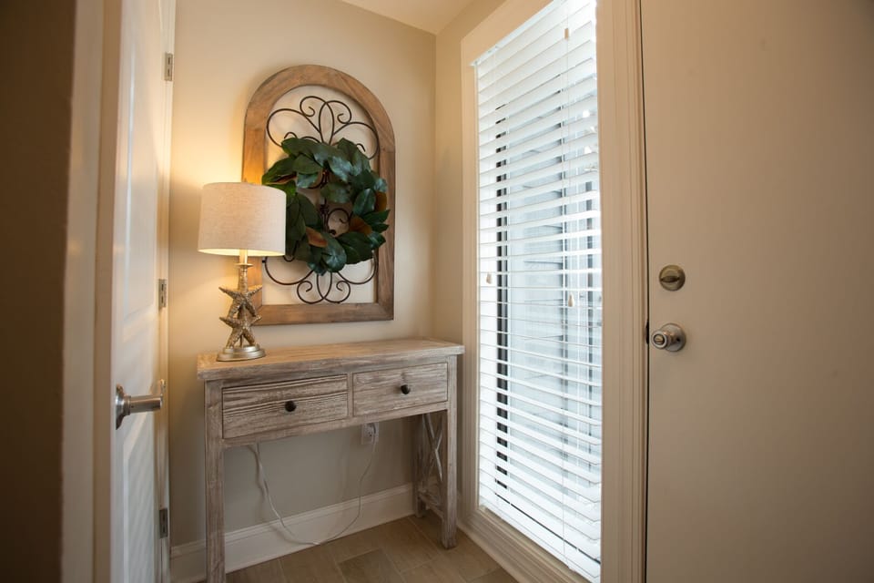 A welcoming entry sets the tone as you step inside, featuring a wood floor foyer with soft coastal colors and classic finishes.