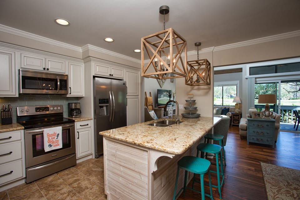Crisp white cabinetry, stainless steel appliances, and warm granite countertops create a clean, inviting workspace.