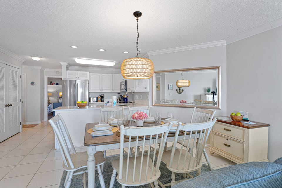 This bright dining area seamlessly connects to the living room, creating an open and inviting space for gathering after a day at the beach.