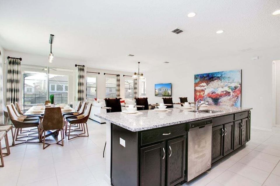 Wide angle view of kitchen island looking into living and dining areas