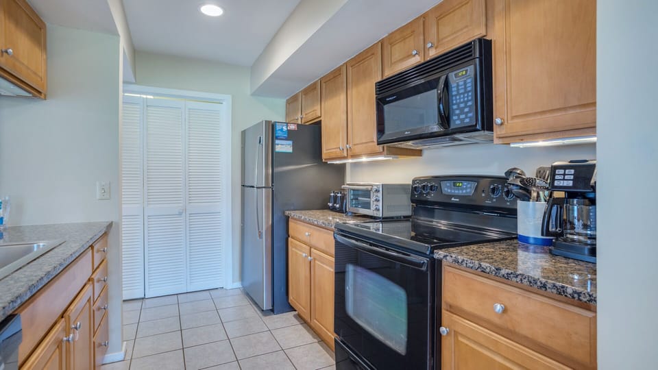 The full appliance package includes a refrigerator, electric range, microwave, dishwasher, coffee maker, and toaster—everything needed for easy breakfasts, beach-day lunches, or family dinners.