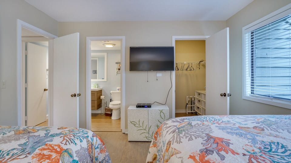 Thoughtful touches, TV, soft lighting, and a clean layout make this room both practical and welcoming for a restful night's sleep.