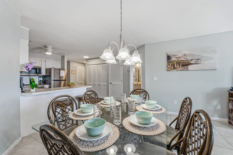 The glass-top table comfortably seats six and flows easily into the kitchen and breakfast bar, keeping conversations connected.