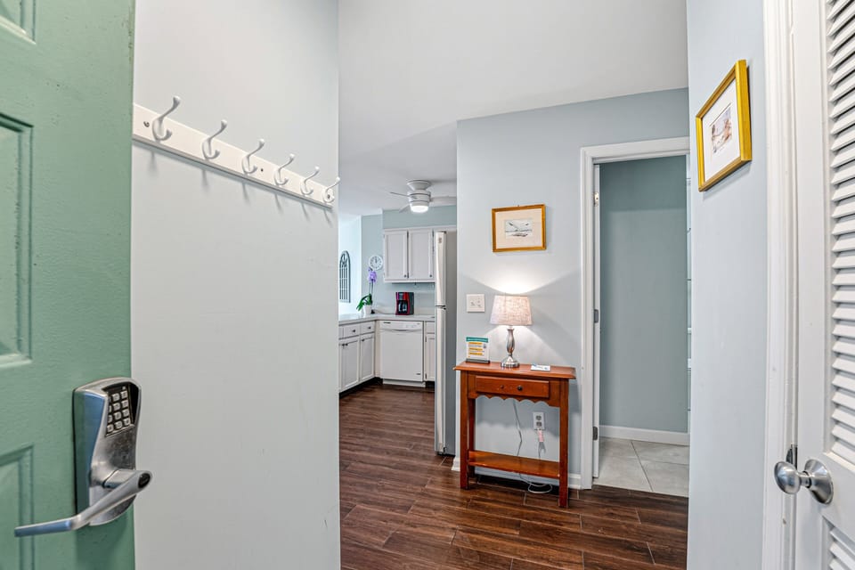 A welcoming entry sets the tone as you step inside, featuring a wood floor foyer with soft coastal colors and classic finishes.