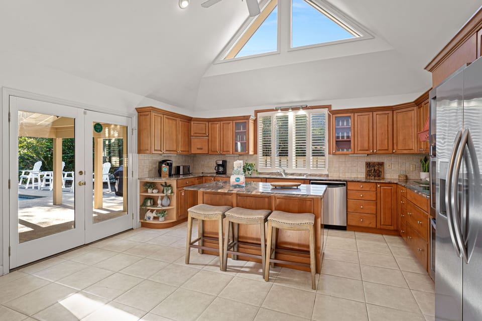 This bright, open kitchen offers generous counter space, warm wood cabinetry, and a large center island with seating.