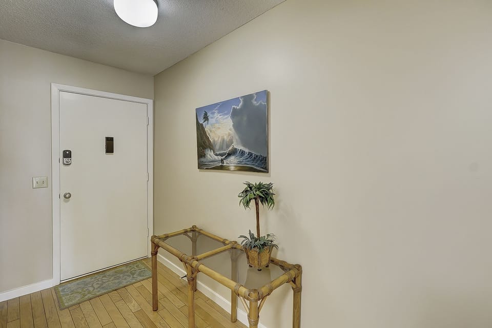 A welcoming entry foyer sets the tone with clean lines and a neutral palette. Wood flooring adds warmth, while the overhead lighting create a bright, inviting first impression.