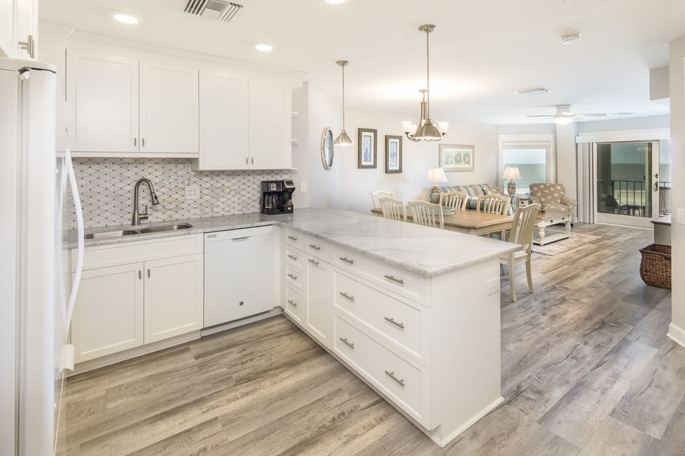 The large peninsula offers extra prep space and seating, flowing seamlessly into the dining and living areas—perfect for entertaining, family meals, and relaxed beach evenings.