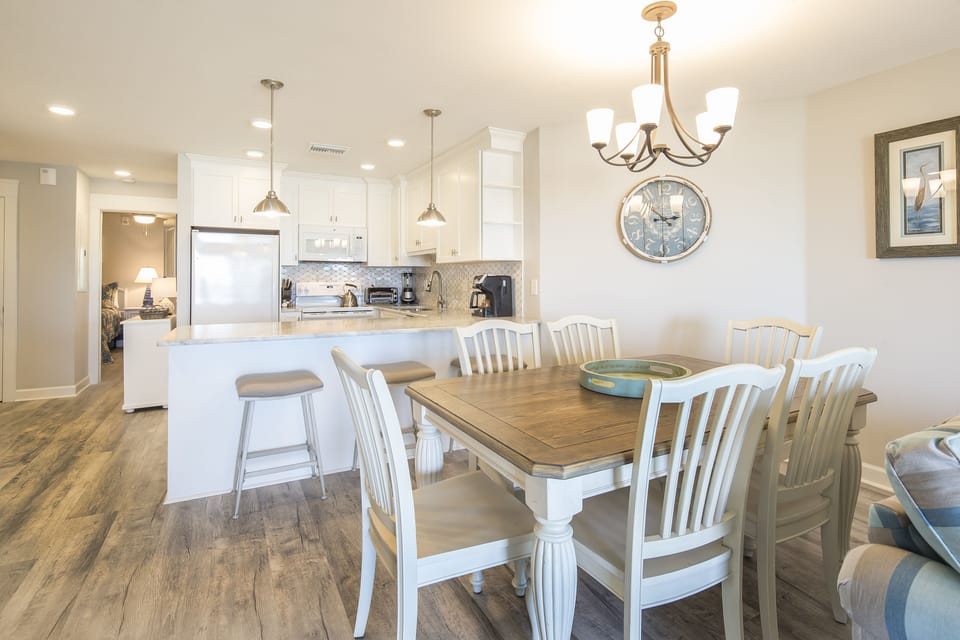 The spacious table seats six, with additional bar seating at the breakfast counter—ideal for shared meals, coffee mornings, and gathering together after a day on the beach.