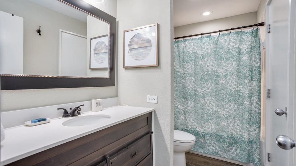 This bathroom is clean, bright, and thoughtfully updated with a modern vanity and a full tub-and-shower combo
