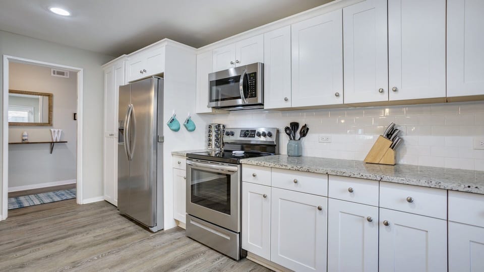This bright, updated kitchen features crisp white cabinetry, granite countertops, and stainless-steel appliances that make meal prep easy and efficient.