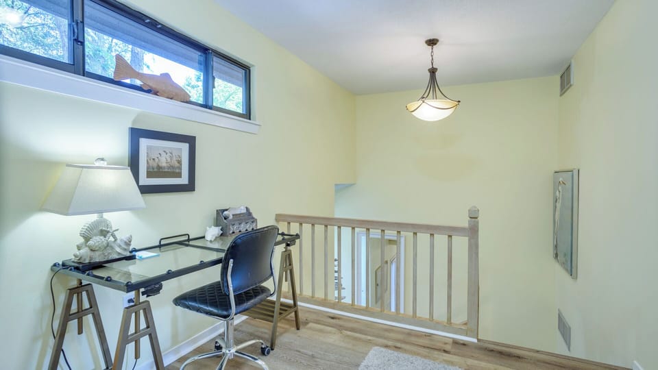 A desk nook creates a flexible space for a home office, planning station, or reading area, while the open railing keeps the area light and connected to the main living space below.