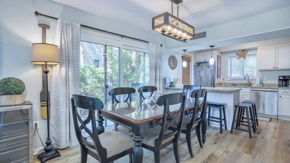 Natural light pours in through the sliding glass doors, offering easy access to the deck and wooded views beyond.