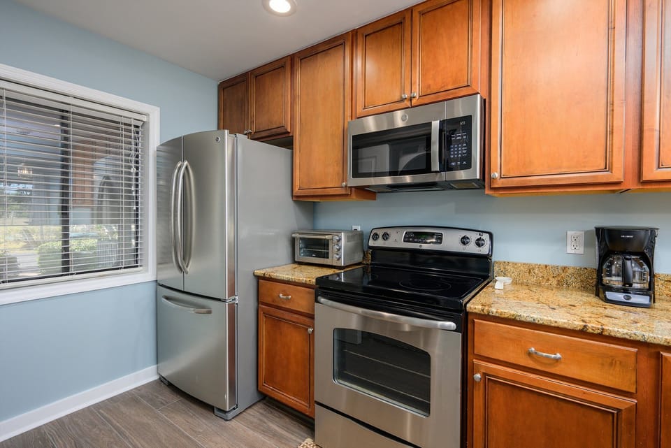Stainless steel appliances—including a full-size refrigerator, range, and microwave—make meal prep easy, while ample counter space and storage support.