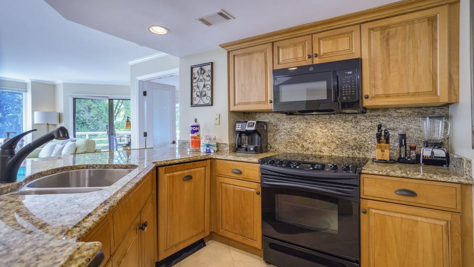 Stainless steel appliances, including a full-size refrigerator, range, microwave, and dishwasher, make meal prep easy and efficient.