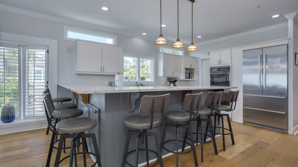 The bright and spacious kitchen features an oversized island with seating for six, making it easy for everyone to gather for meals.