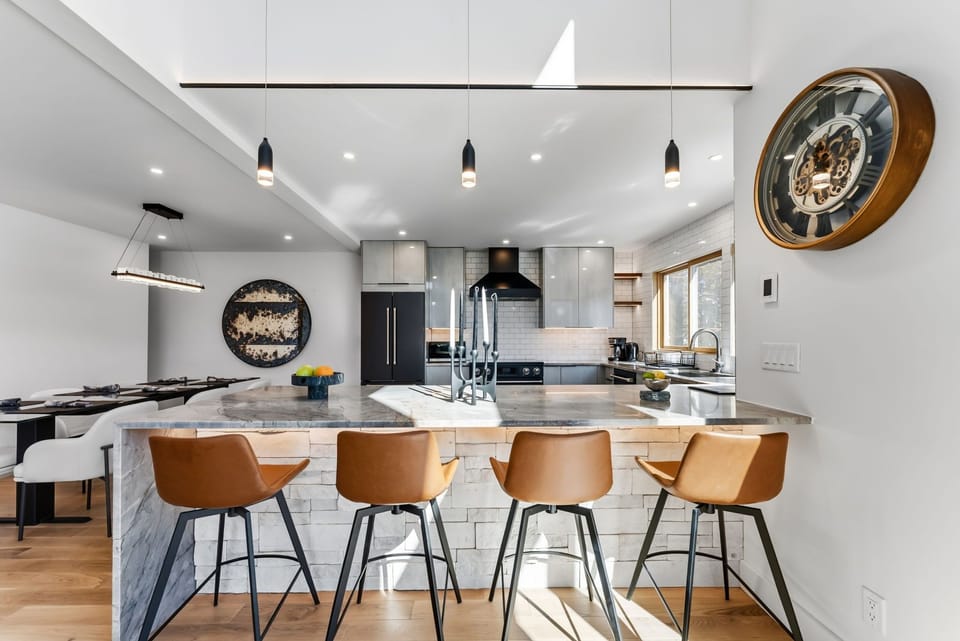 Cook your favorite meals in this stunning modern kitchen featuring sleek appliances, spacious marble island, and stylish bar seating for memorable culinary moments.