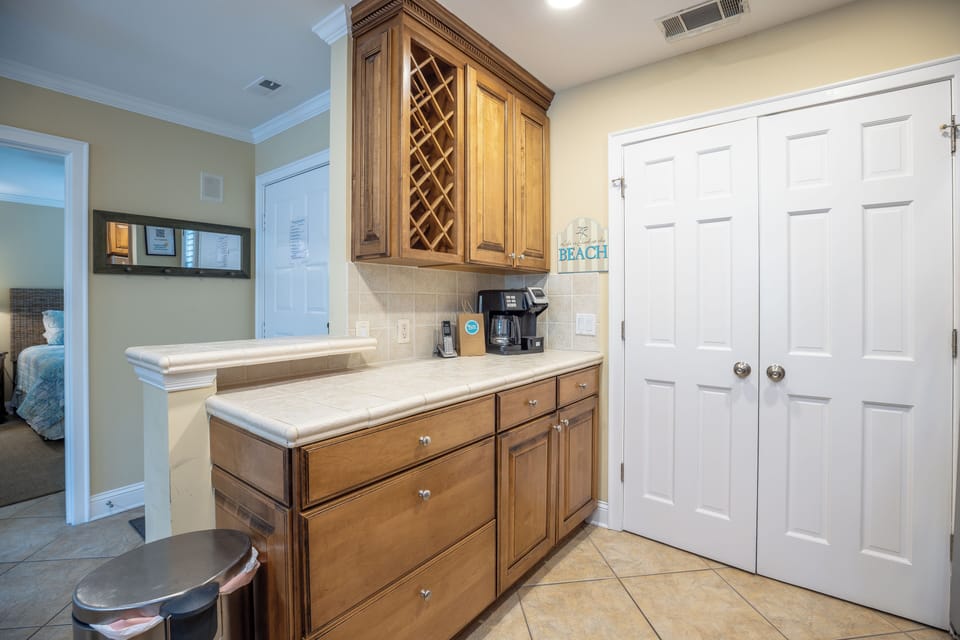 Featuring rich wood cabinetry, a built-in wine rack, generous counter space, and a dedicated coffee station, it's ideal for entertaining or easy everyday living.