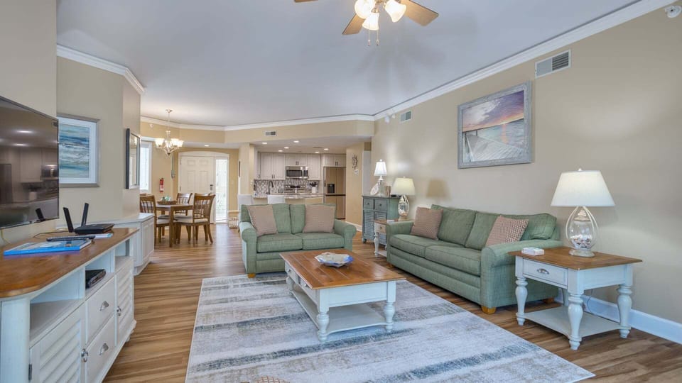 A comfortable sofa anchors the space, complemented by a cozy reading chair and warm wood accents.