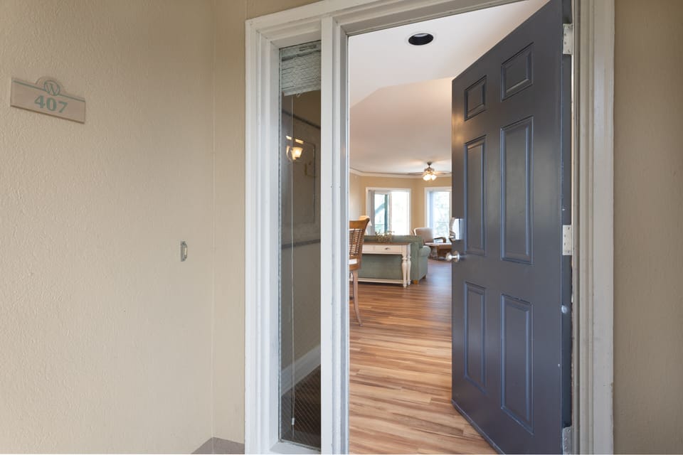 A welcoming entry sets the tone as you step inside, featuring a wood floor foyer with soft coastal colors and classic finishes.