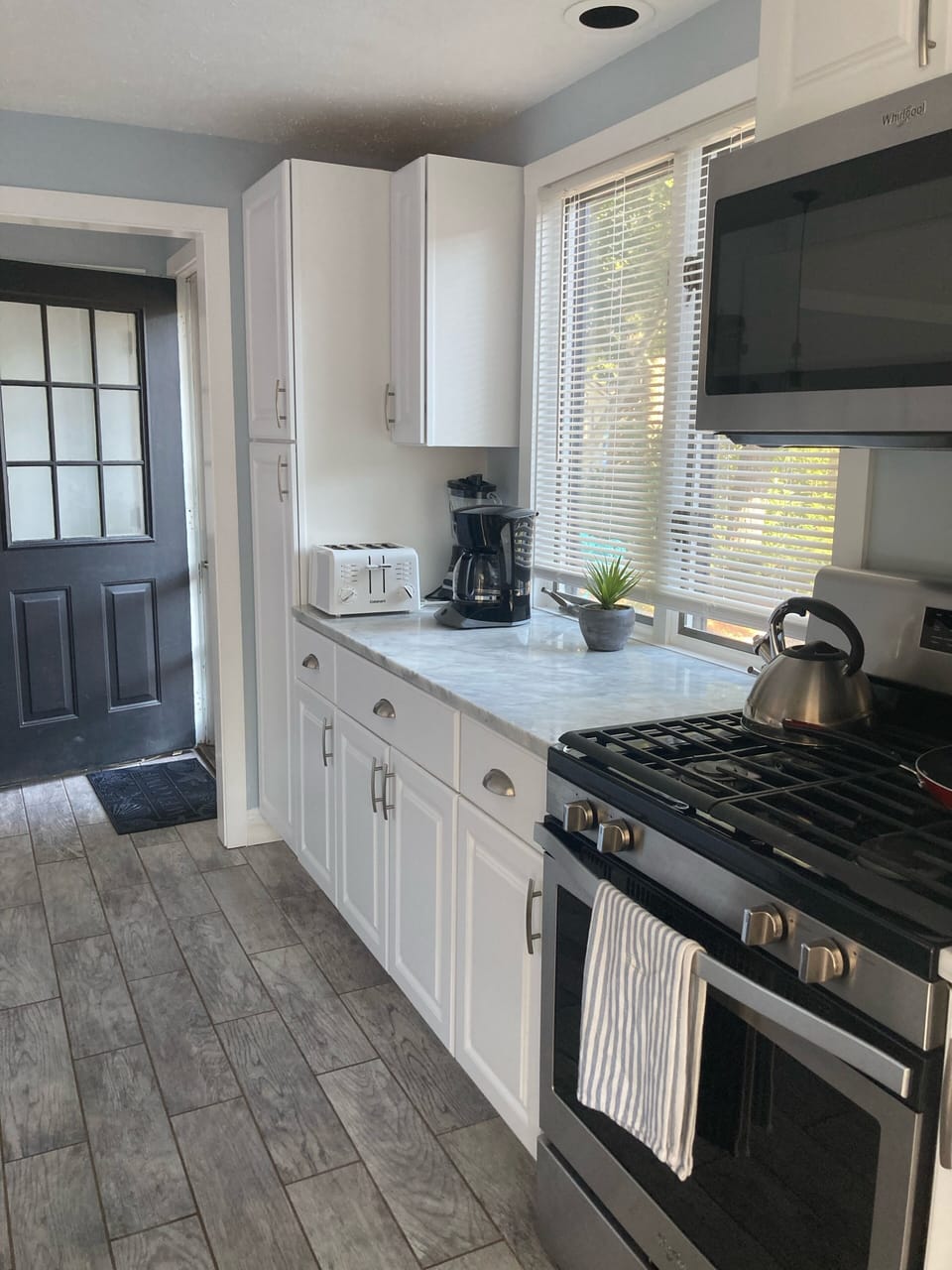 Updated kitchen with modern appliances and marble countertops