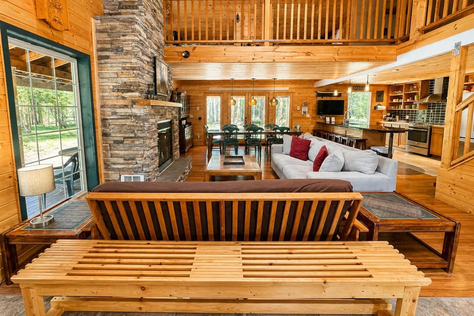 Imagine unwinding in this soaring open-concept retreat, where rustic wood, stone fireplace, and lofted beams create warmth and comfort for your group getaway.