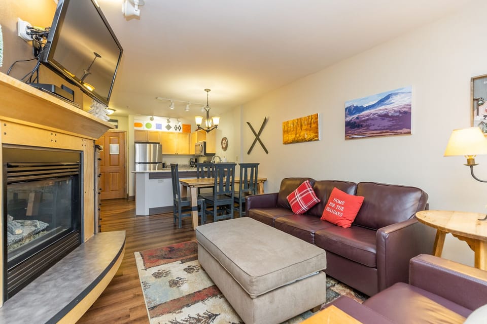 Cozy up in your mountain retreat with leather seating, warm fireplace, and open kitchen perfect for preparing meals after outdoor adventures.