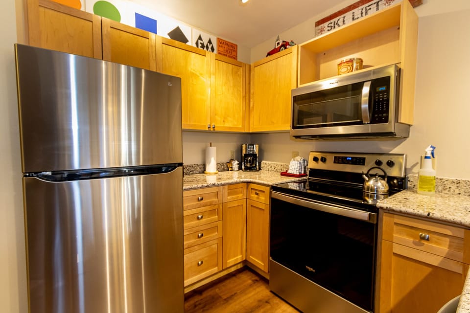 Your fully equipped kitchen features modern stainless steel appliances, granite countertops, and warm wood cabinets for all your culinary adventures.