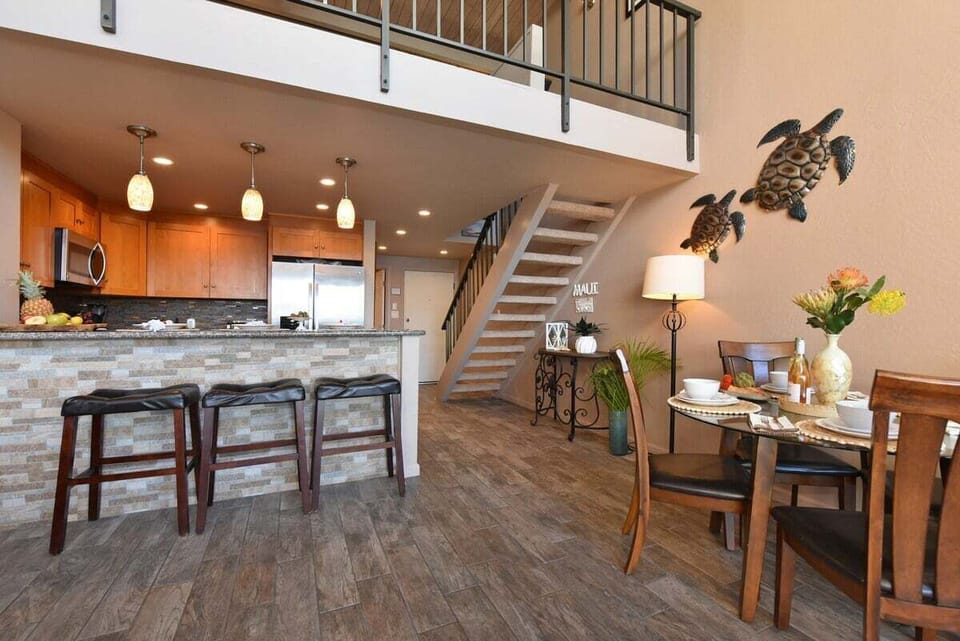 A seamless flow from the kitchen to the dining area makes this home perfect for social gatherings. Coastal decor and warm lighting create a welcoming island atmosphere.