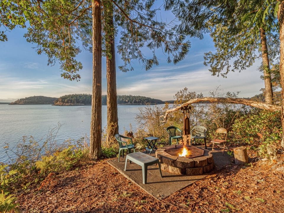The fire pit and rustic steps to the water. (Fires are not allowed May- September due to seasonal county burn ban)

If your goal is to embrace the convergence of the wilderness and earthly comforts, all manner of seafaring along with intermittent but absolute silence, or a heavenly sunset by the fire while you still count yourself among the living, come and sit a while.
