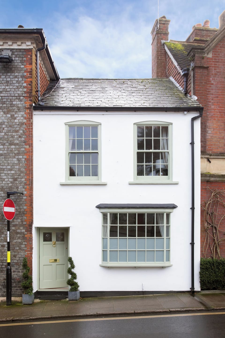 Street view, white house with sage green door and windows 
