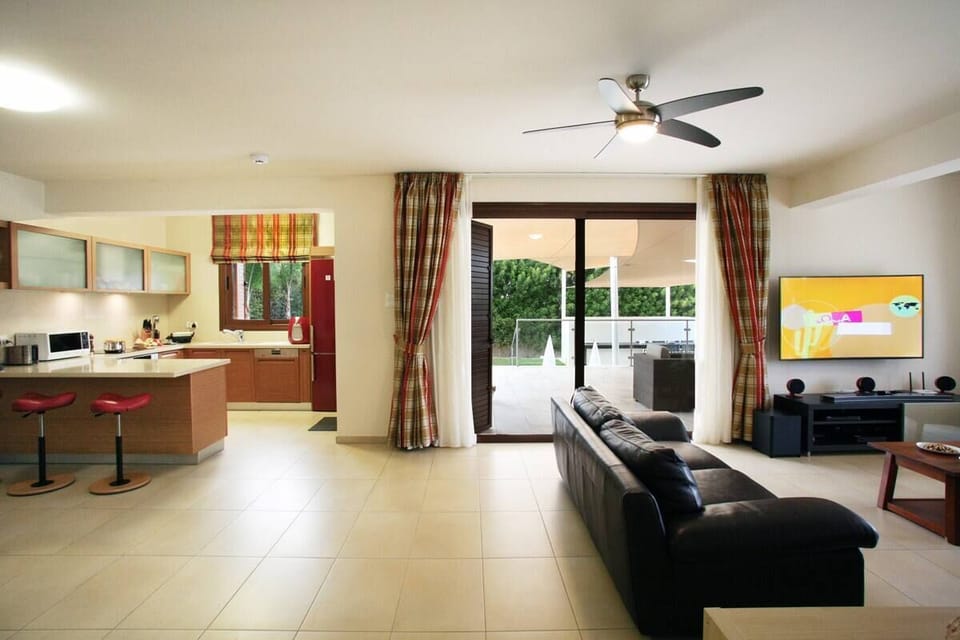 The Lounge, TV stand, Kitchen and sliding door leading to the Outdoor Terrace!