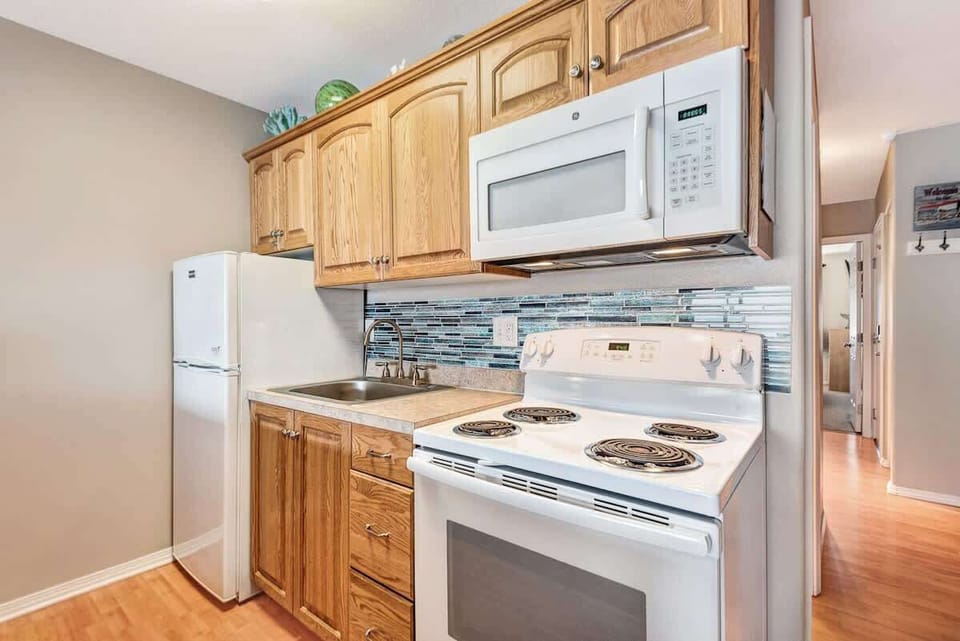 The full kitchen has a fridge, stove, and oven
