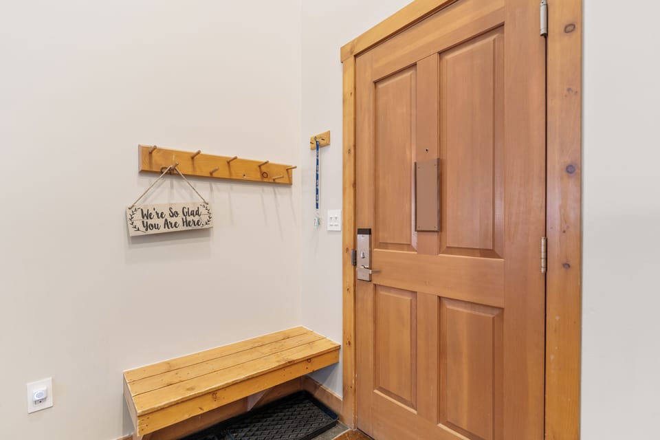 Step into your welcoming entryway with rustic wooden bench and cheerful welcome sign setting the perfect tone for your stay.