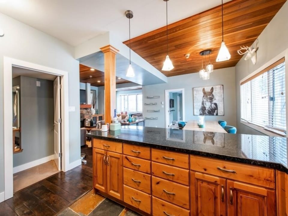 Large central kitchen area.  Well decorated, well stocked home. door to left is bedroom 2, door beside horse is bedroom 3. Far windowed area is kids games area. Living room (fire & TV) to the left of dining area.