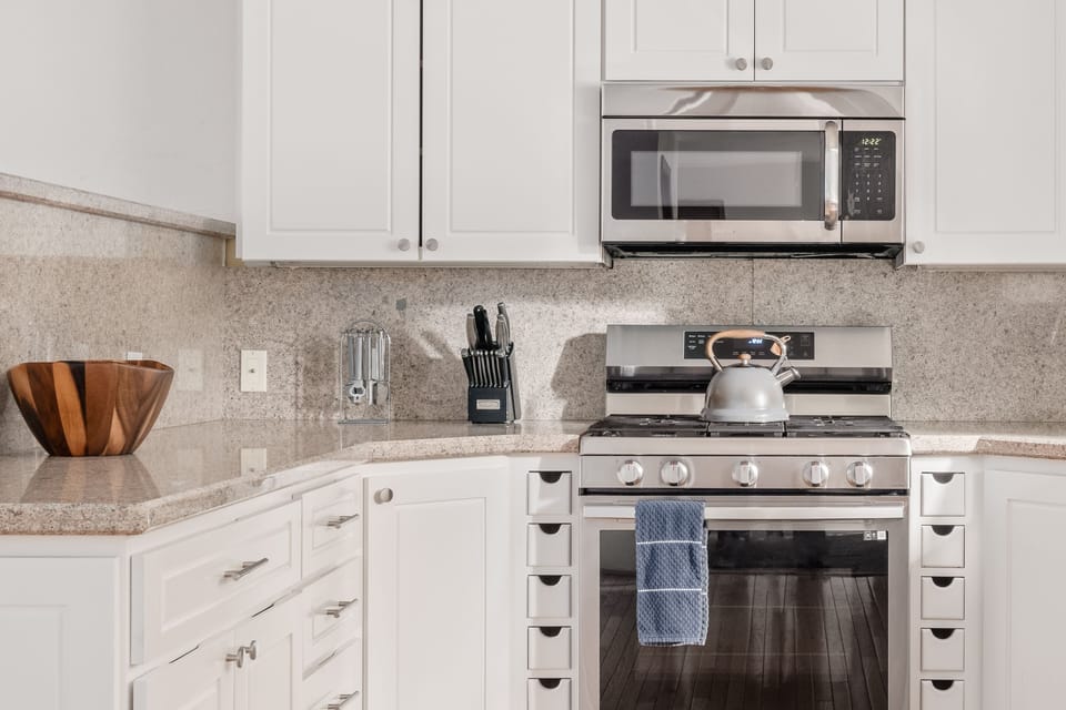 - Stainless steel stove with oven and microwave  
- Granite counters and bright white cabinetry  
- Fully stocked kitchen ready for family cooking