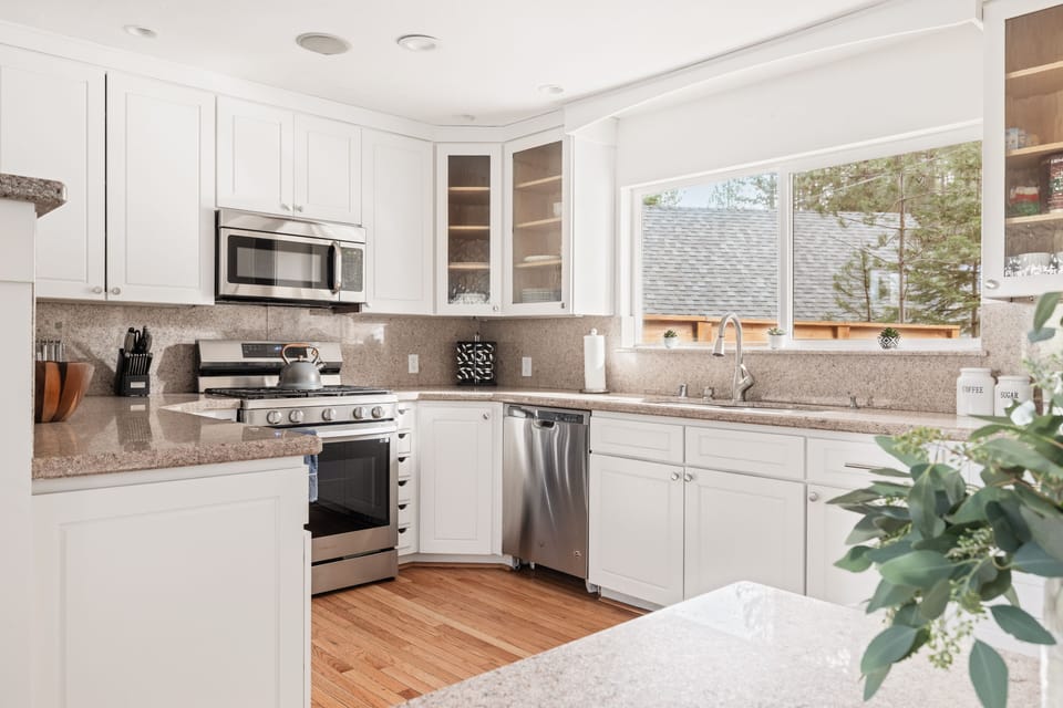 - Modern kitchen with stainless steel appliances  
- White cabinetry and granite countertops throughout  
- Fully equipped for home-cooked cabin meals