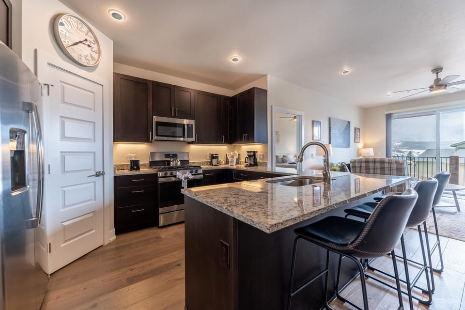 Prepare meals in your fully equipped kitchen with granite counters, modern appliances, and bar seating overlooking stunning lake views.