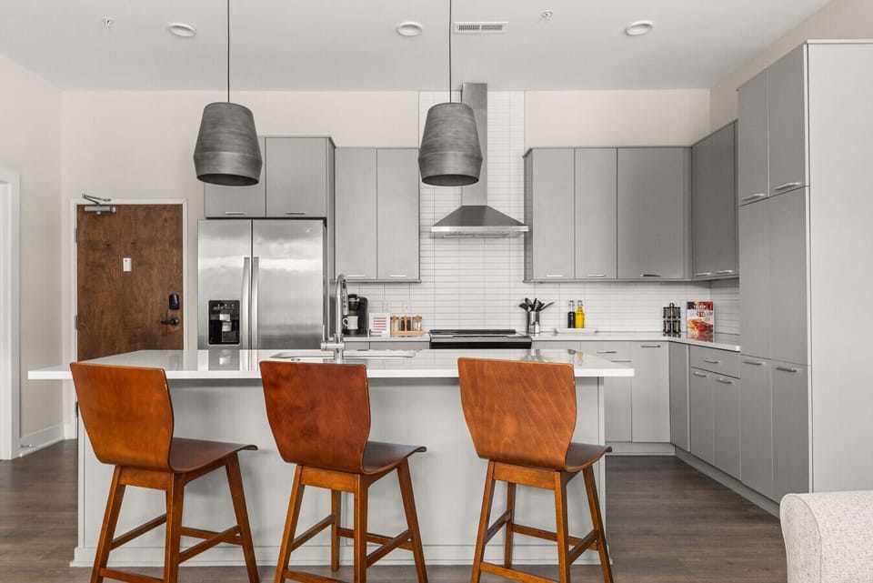 Sleek kitchen with stainless steel appliances, a generous island, and stylish seating.