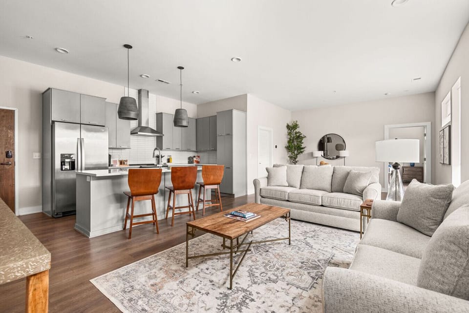 Open-concept living area with abundant natural light, a modern kitchen with island seating, and cozy, stylish furnishings throughout.