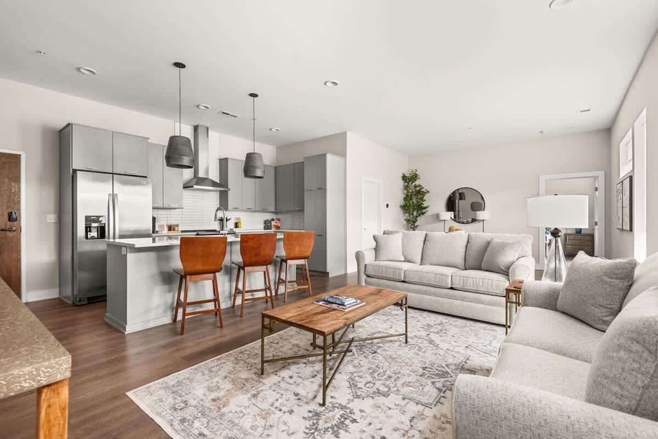 Open-concept living area with abundant natural light, a modern kitchen with island seating, and cozy, stylish furnishings throughout.