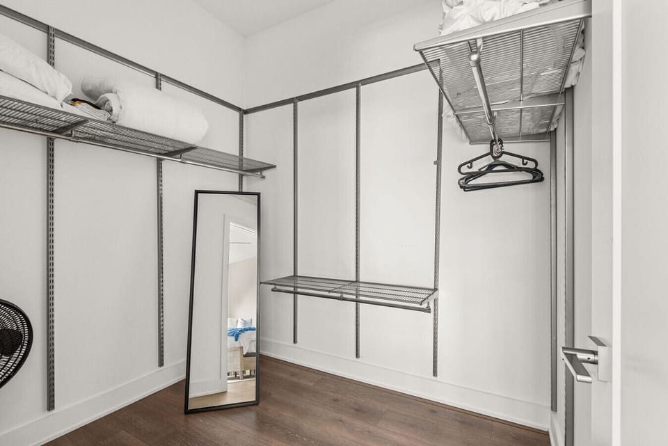 Spacious walk-in closet with custom shelving and hardwood floors.